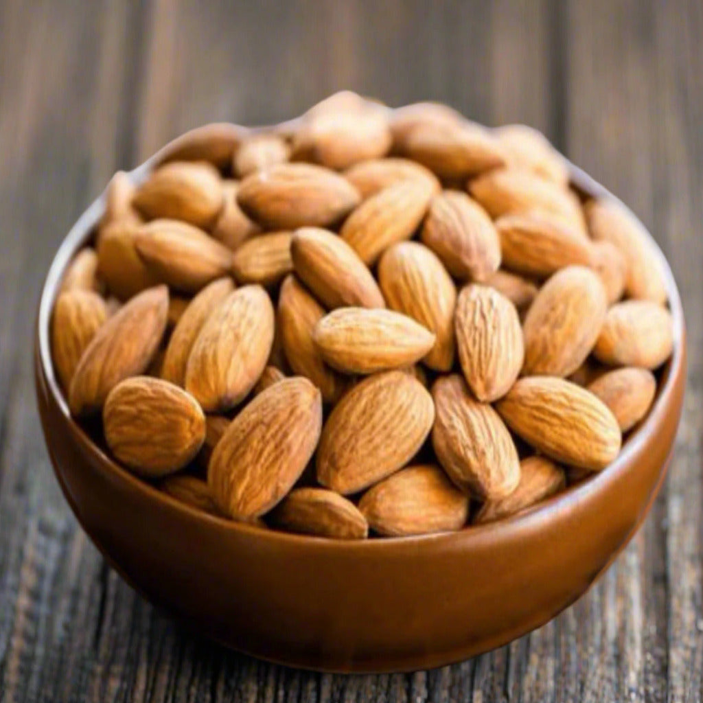 a bowl of whole roasted almonds used to make almond toffee.